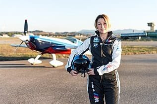 Mélanie Astles pose devant son appareil de voltige Extra 330 SC.