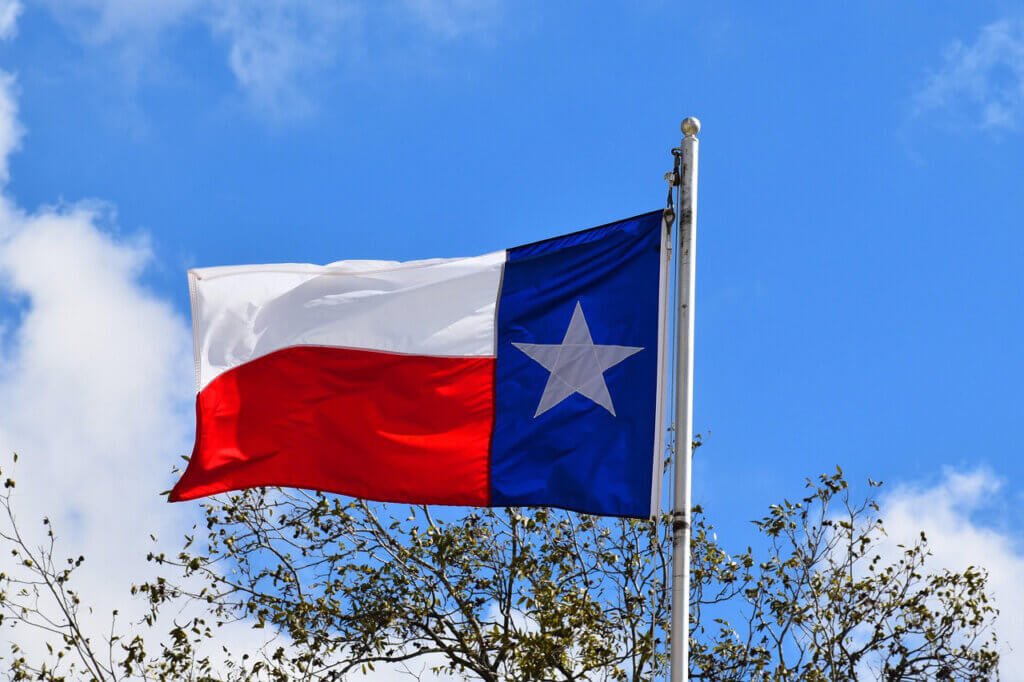 Drapeau du Texas flottant au vent, étoile blanche sur fond bleu, bandes blanche et rouge.