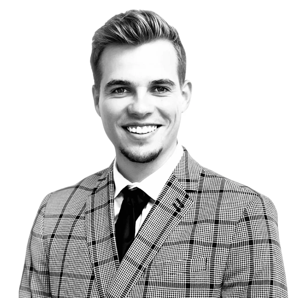 Investissement USA Portrait de Romain Daniellou, co-fondateur de LandQuire, en costume à carreaux, souriant, sur fond blanc.