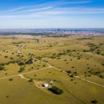 Achat terrain Abilene Texas : vue aérienne d'un vaste terrain à vendre avec la skyline de la ville en arrière-plan, symbolisant le potentiel d'investissement en 2025.
